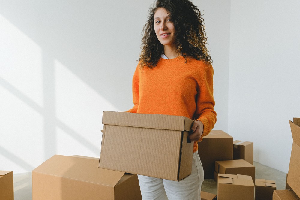 une personne installée dans son nouvel appartement entourée de cartons
